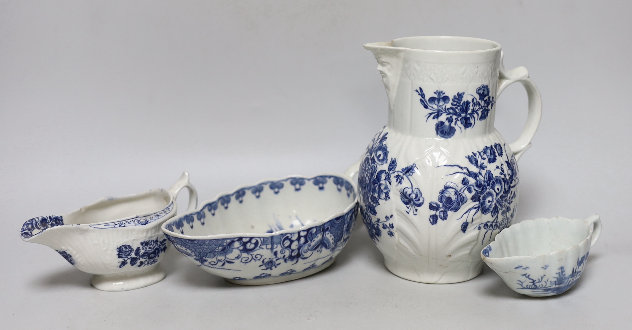 An 18th century Worcester blue and white cabbage-leaf mask jug, two similar sauceboats and an 18th century English blue and white sauceboat, a/f, tallest 19cm high